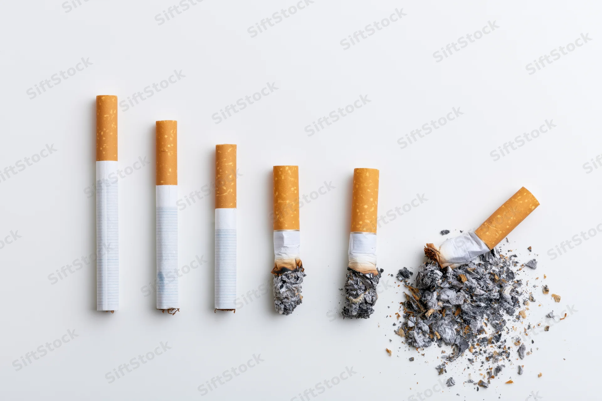 Five cigarettes arranged in a row showing progressive stages from whole to crushed with ash on white background