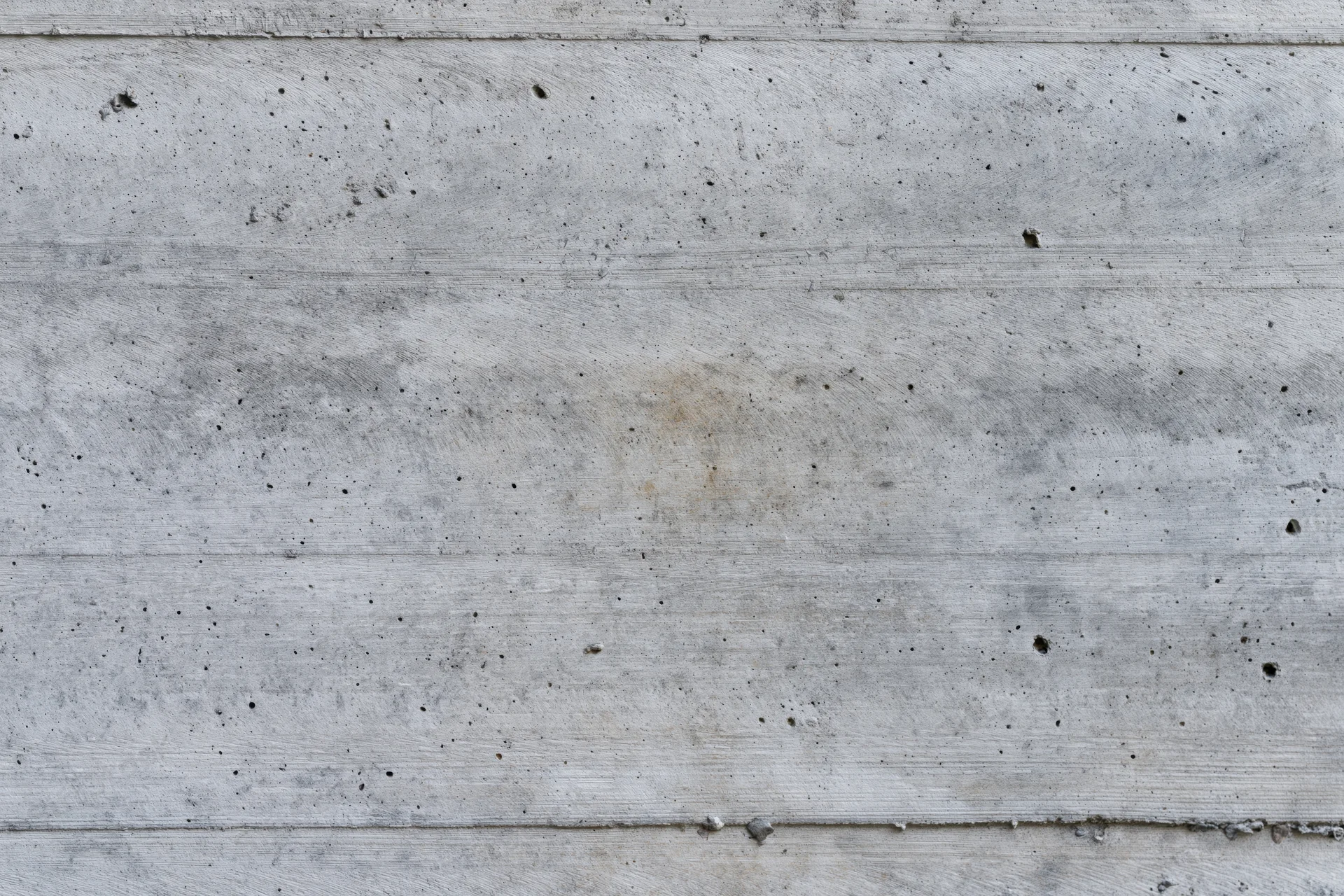 Flat concrete wall surface with horizontal panels and weathered texture