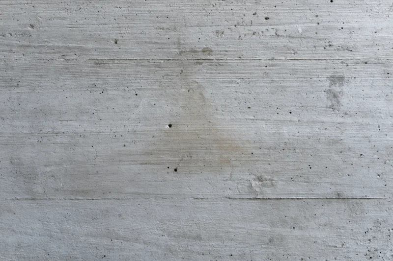 Flat concrete wall surface with horizontal lines and minor imperfections filling the frame