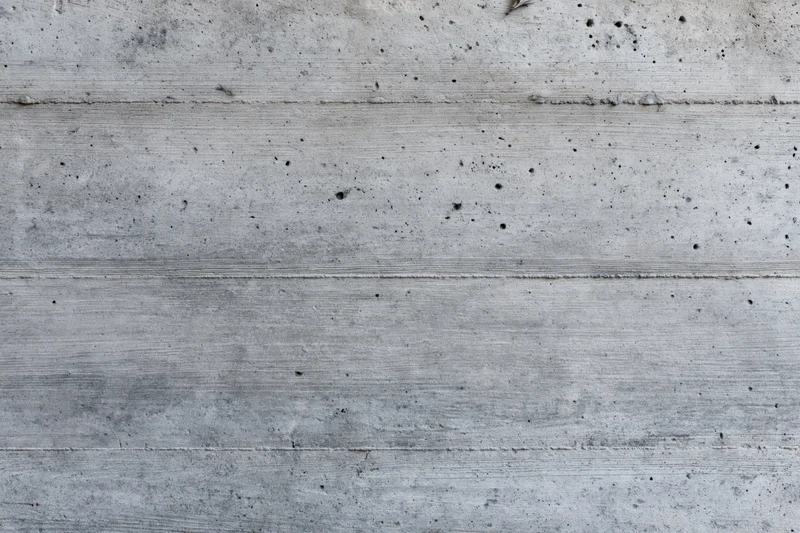 Flat concrete wall surface with horizontal lines and small holes filling the frame