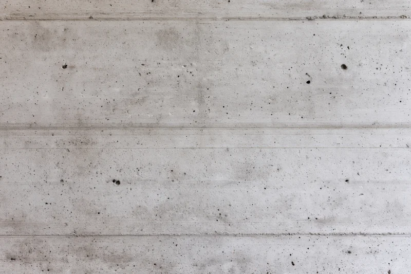 Flat concrete wall surface with horizontal lines and speckled texture filling the frame