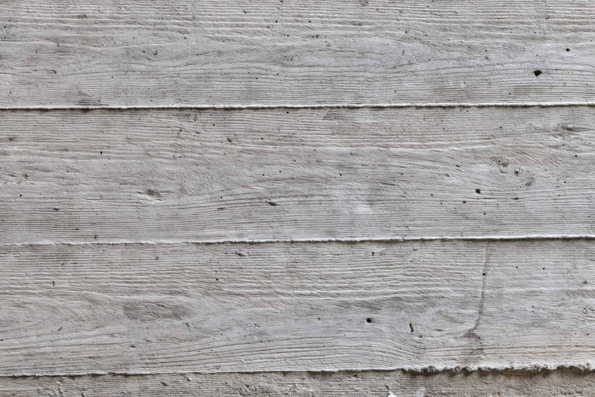 Horizontal formwork lines on a gray concrete wall surface