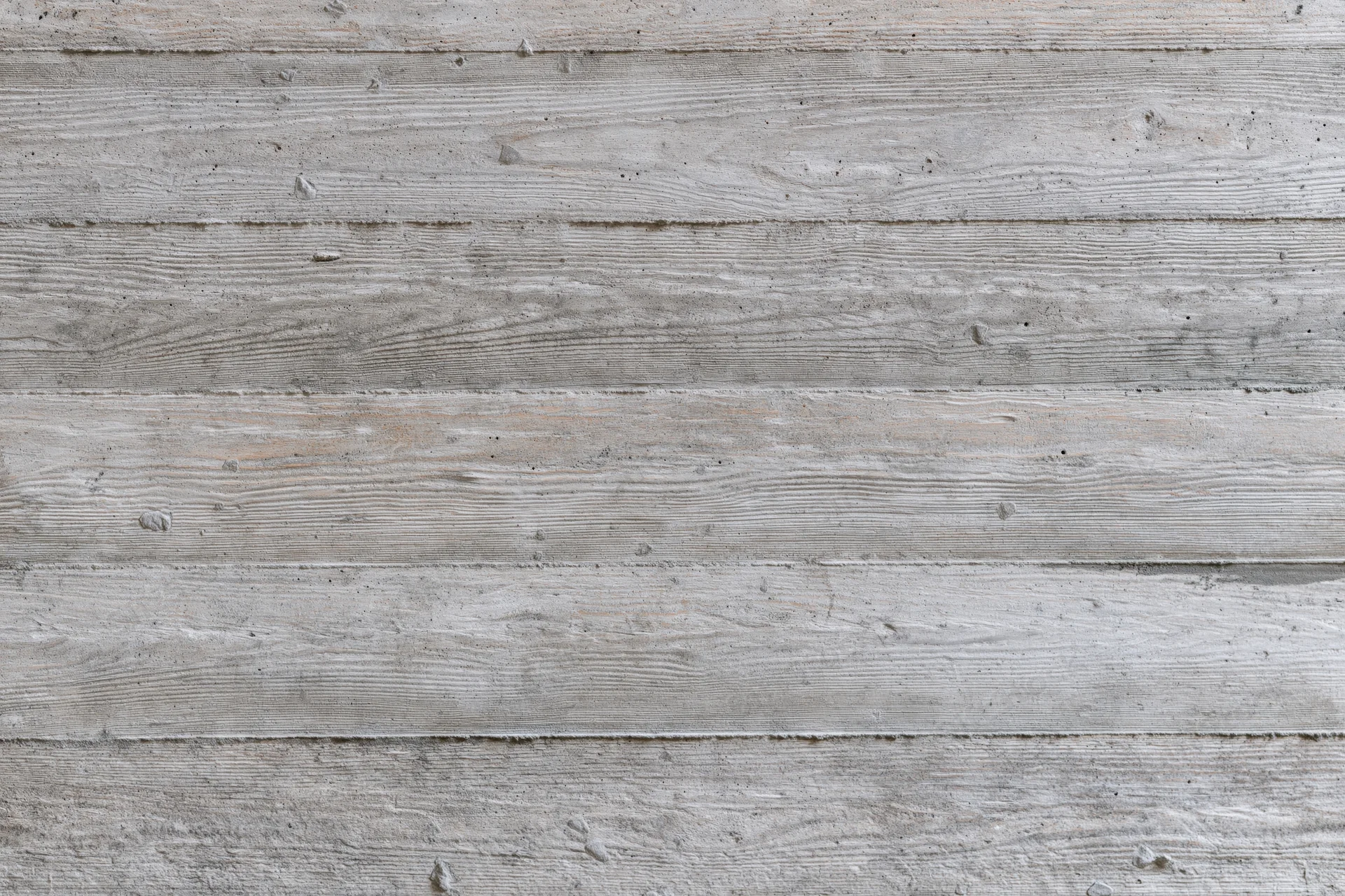 Horizontal formwork lines on a gray concrete wall surface