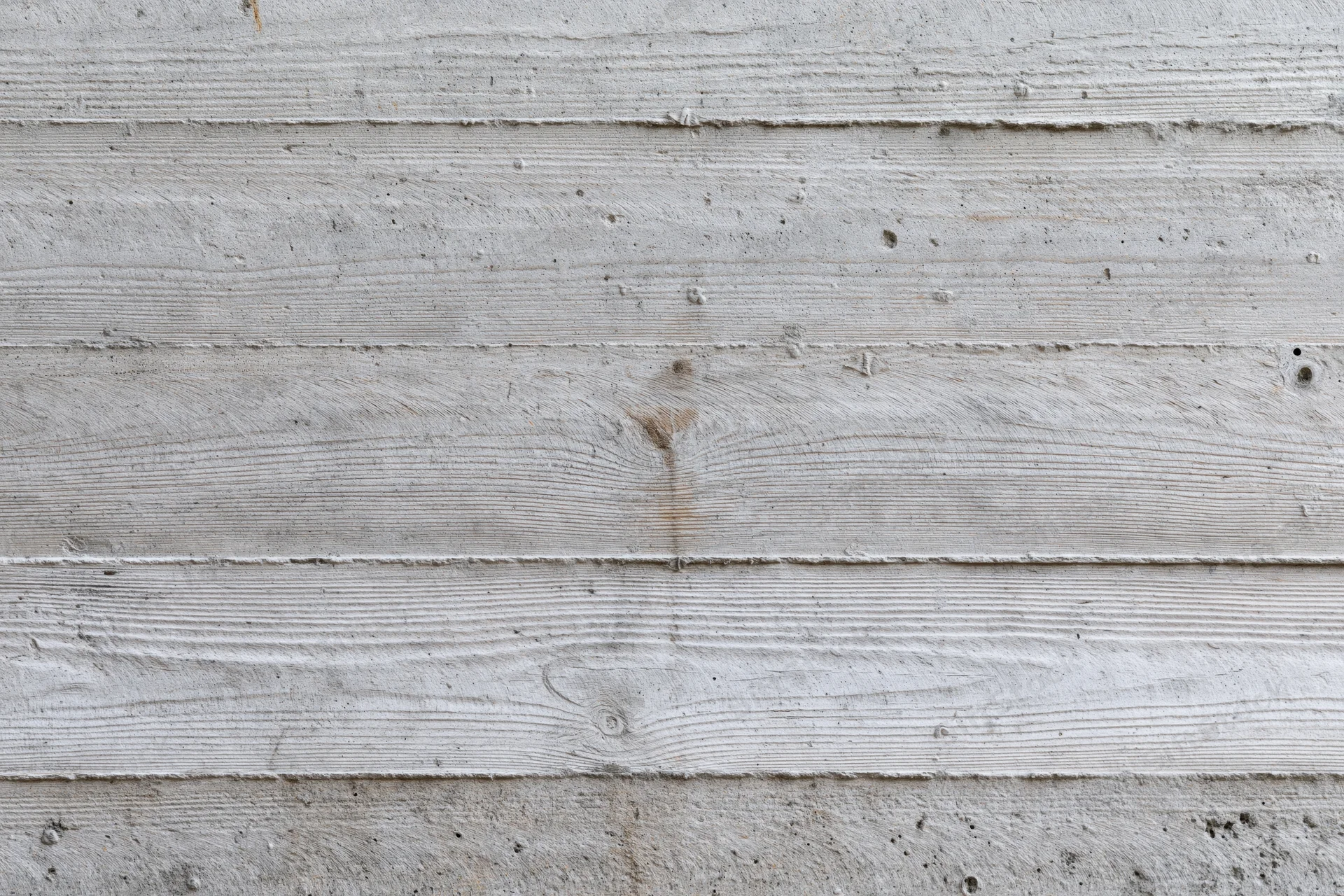 Horizontal formwork lines on a gray concrete wall surface