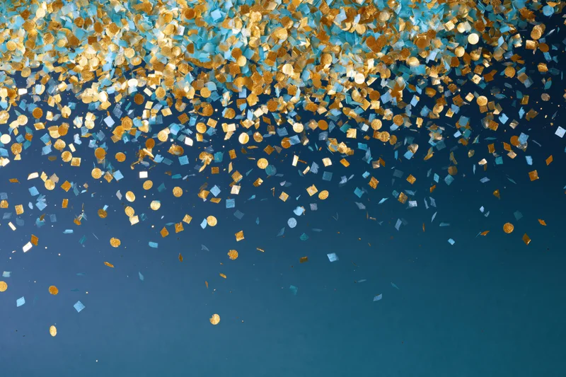 Gold and light blue confetti pieces falling densely against a blue background