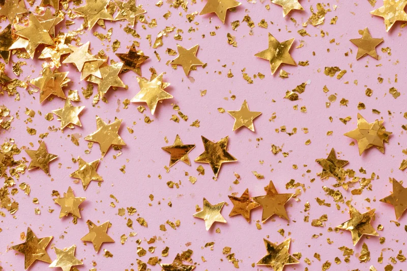 Gold star-shaped confetti and metallic glitter pieces scatter