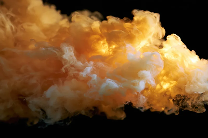 Golden amber smoke billowing against black background