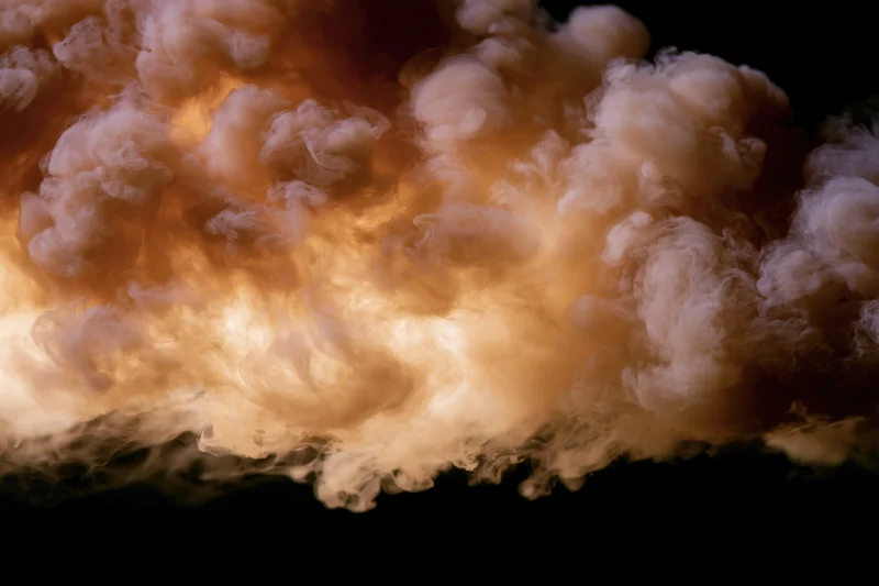 Golden amber smoke billowing downward against a dark background