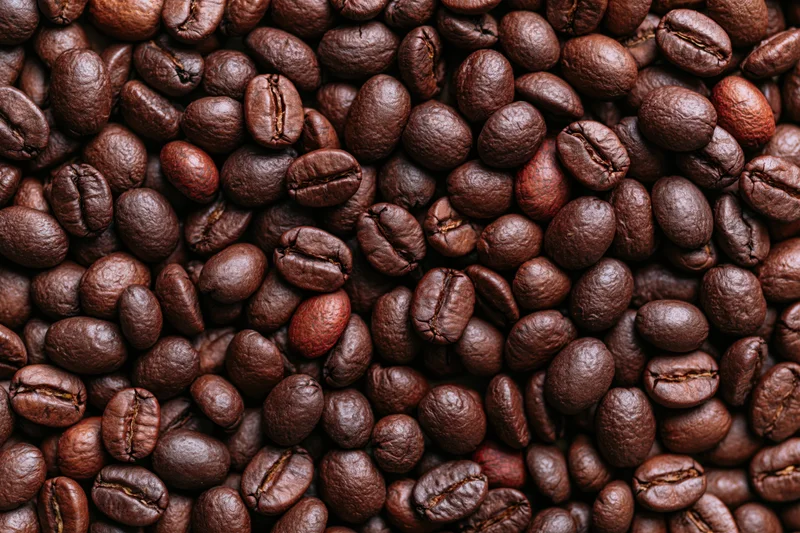 Dark roasted coffee beans filling the frame in a close-up view