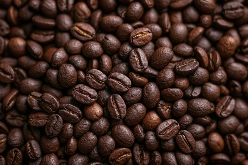 Dark roasted coffee beans filling the frame in closeup view