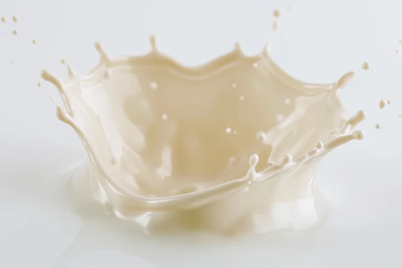 Cream splash frozen mid-motion forming a dynamic crown shape on white background