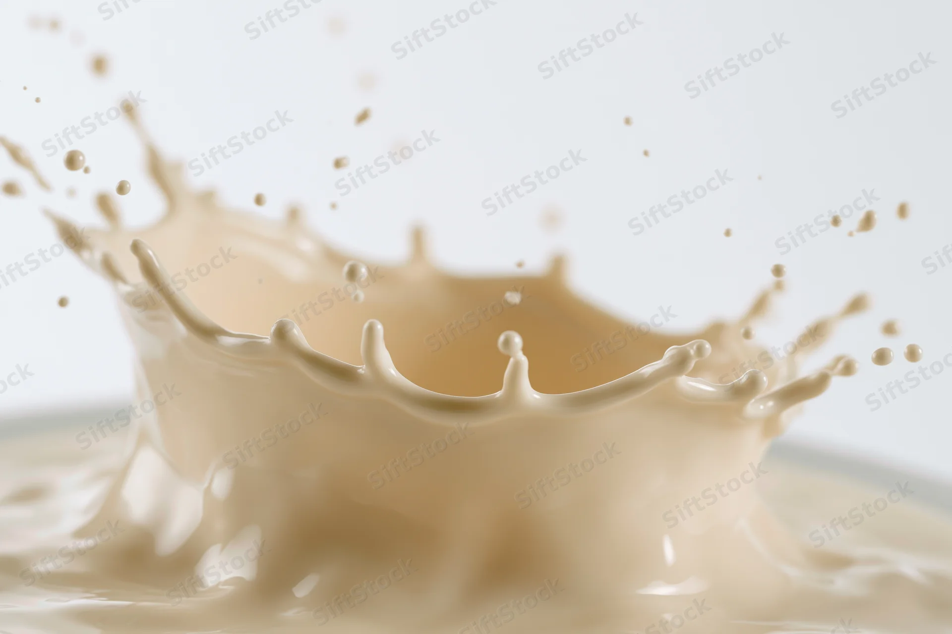 Milk splash frozen mid-motion forming a dynamic crown shape against white background