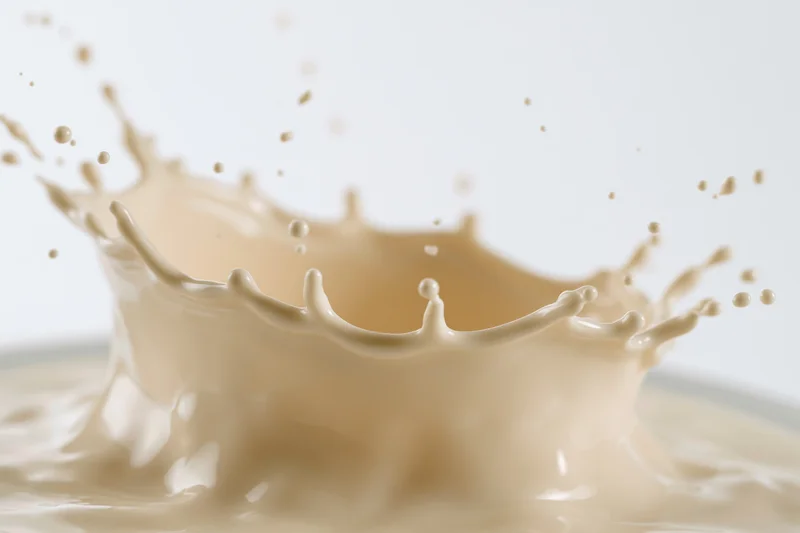 Milk splash frozen mid-motion forming a dynamic crown shape against white background