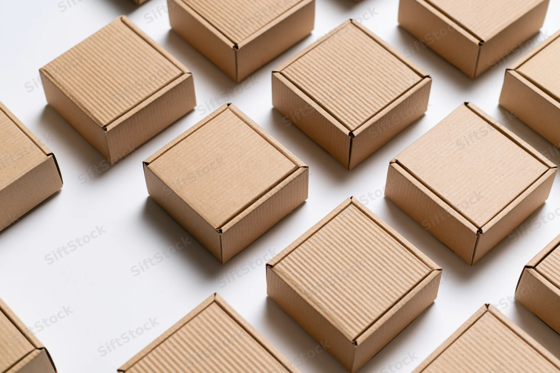 Multiple closed kraft cardboard shipping boxes arranged in a flat lay on white surface