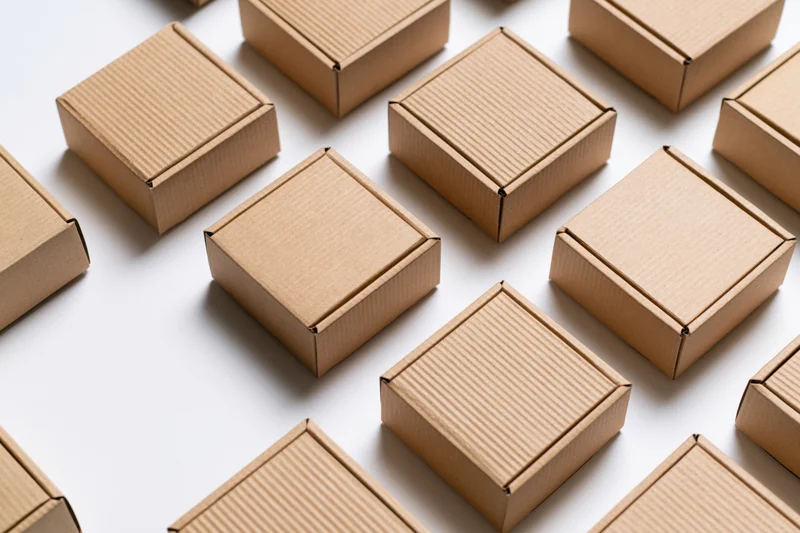 Multiple closed kraft cardboard shipping boxes arranged in a flat lay on white surface