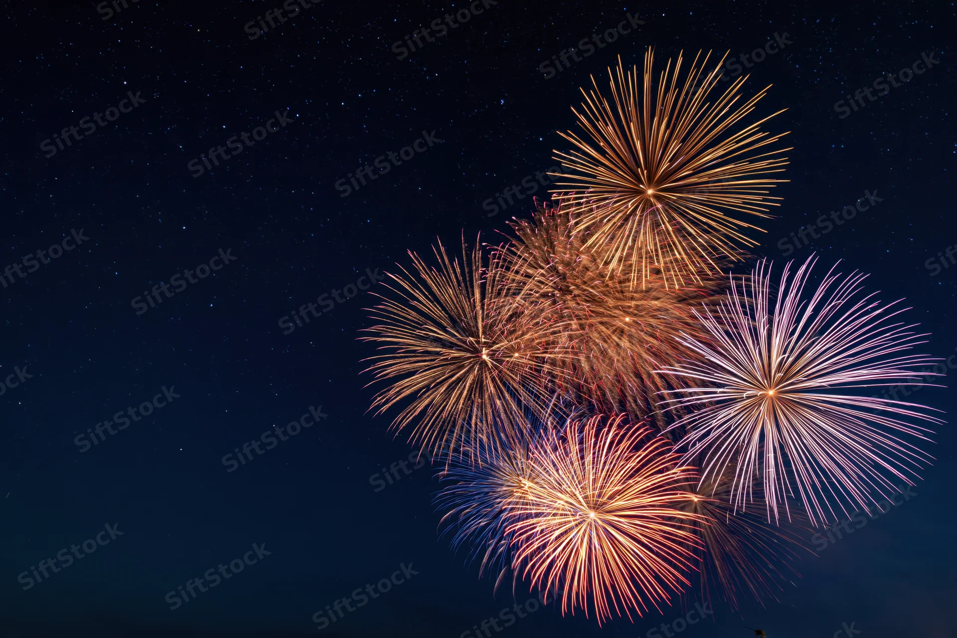 Fireworks bursting in the night sky with stars visible in the background