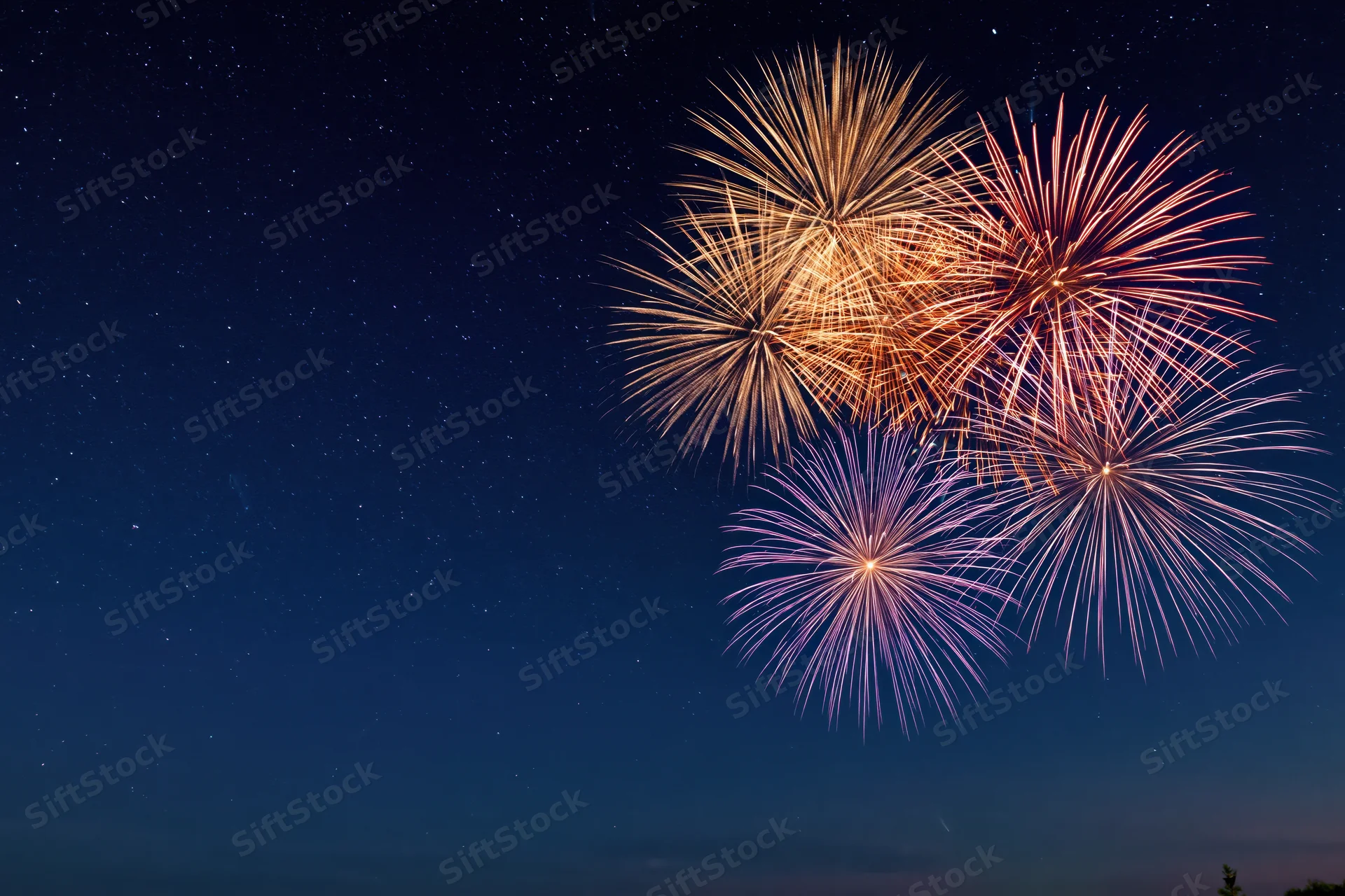 Fireworks bursting in the night sky with stars visible in the background
