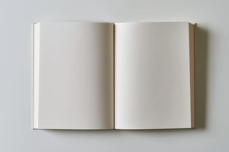 Open blank notebook with empty white pages lying flat on a neutral surface