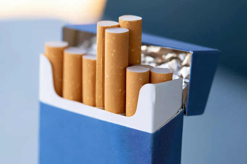 Open blue cigarette pack with several cigarettes protruding