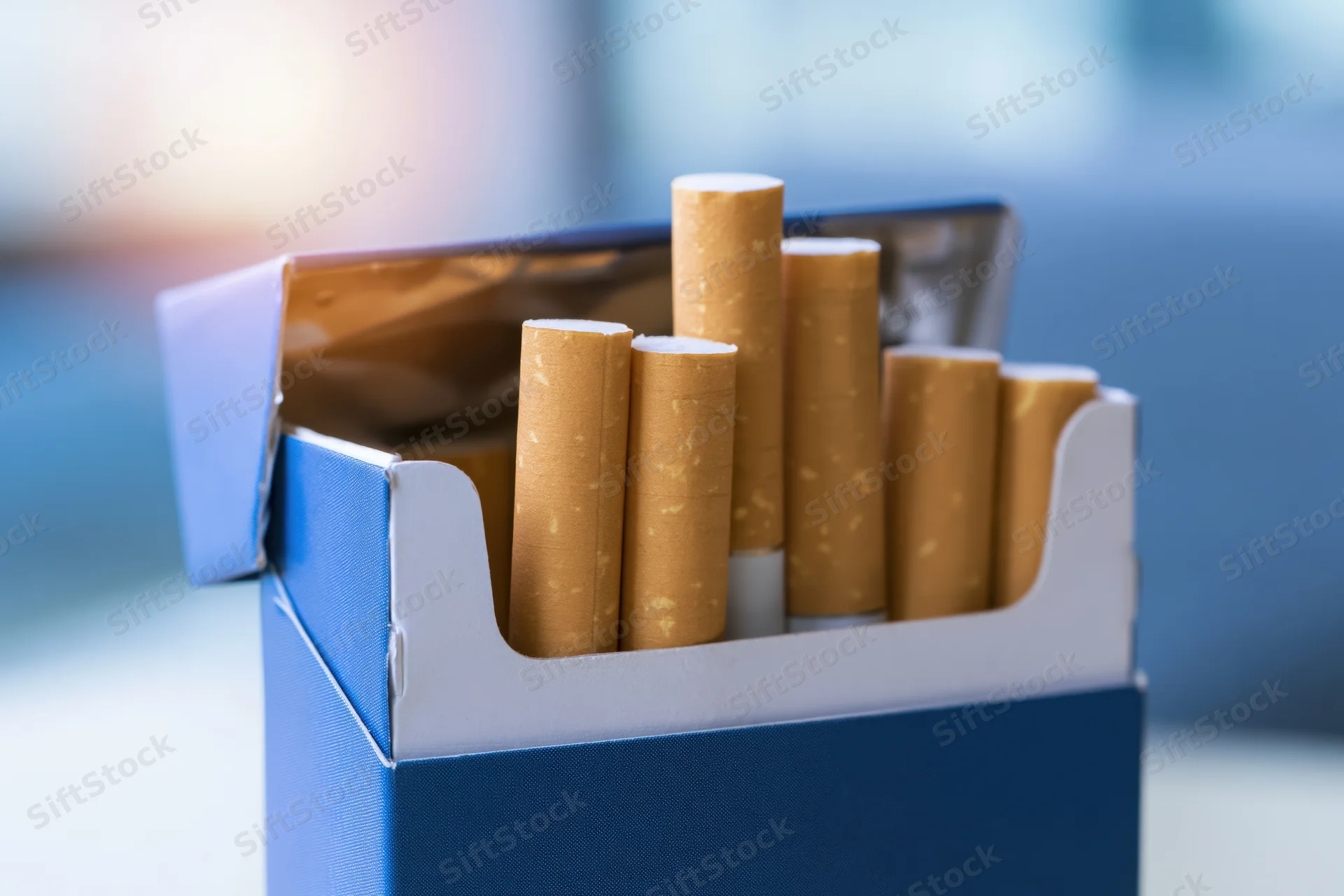 Open blue cigarette pack with several cigarettes protruding, close-up view