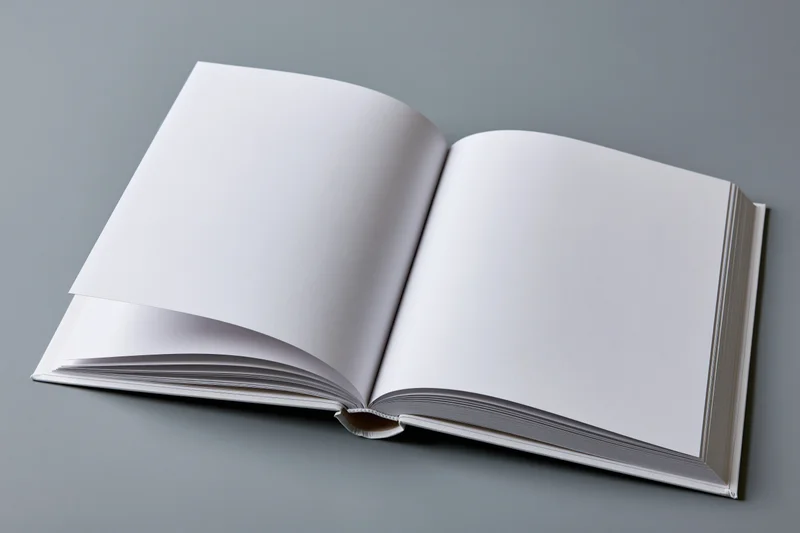 Open hardcover book with blank white pages on gray surface