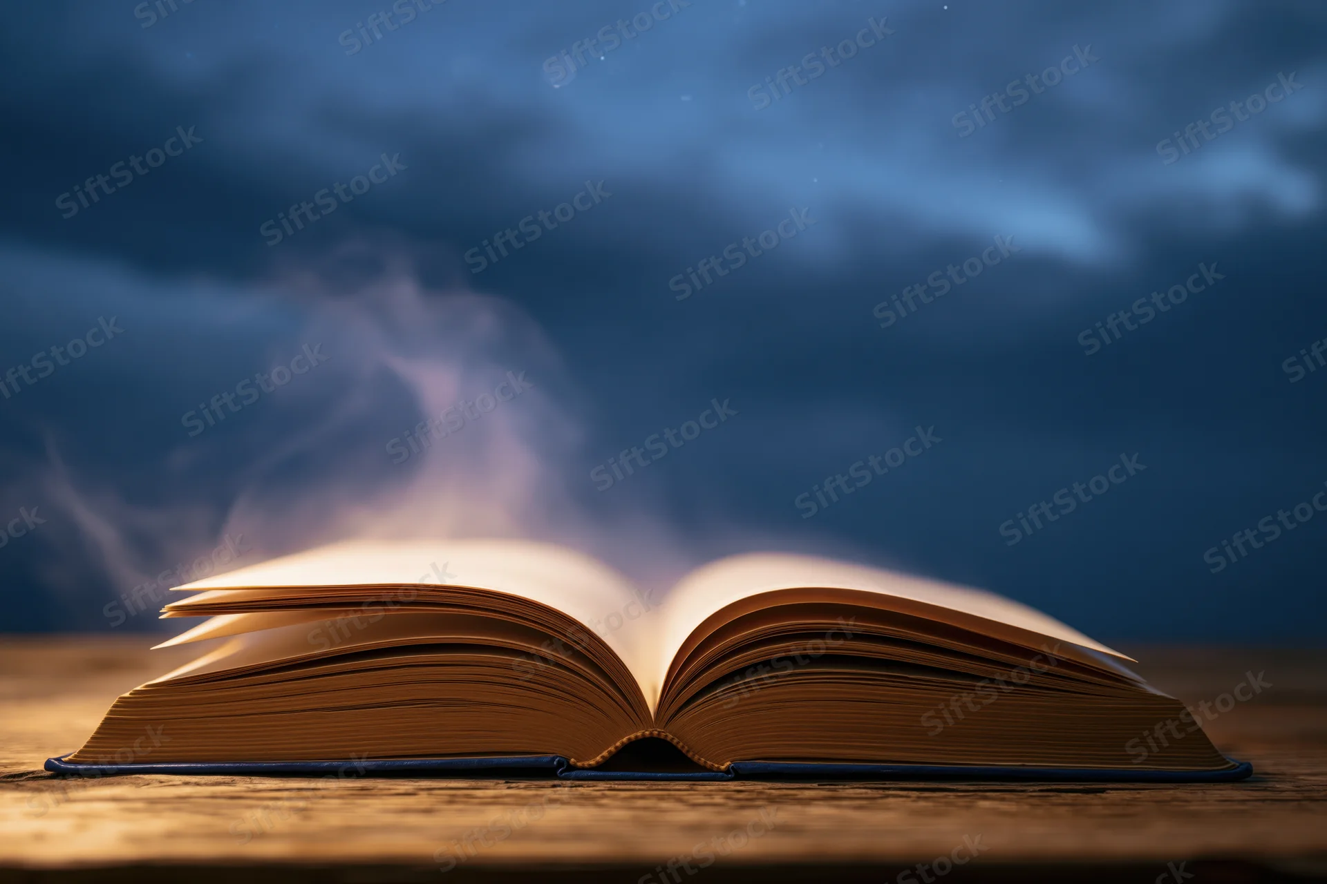 Open hardcover book with glowing pages and rising smoke on a wooden surface under a dark cloudy sky