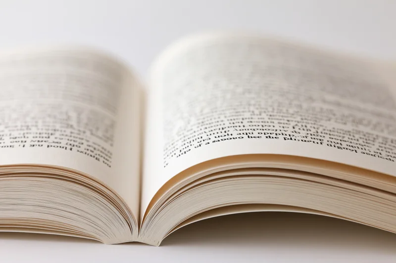 Open paperback book with pages spread on white background