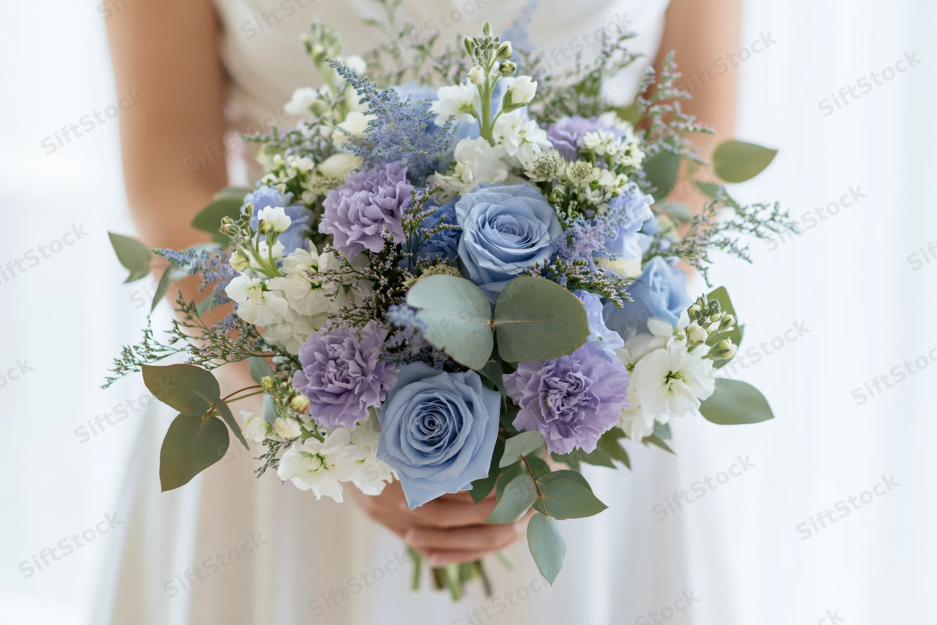 Bride holding a lush bridal bouquet of blue roses, lavender, and white flowers with greenery