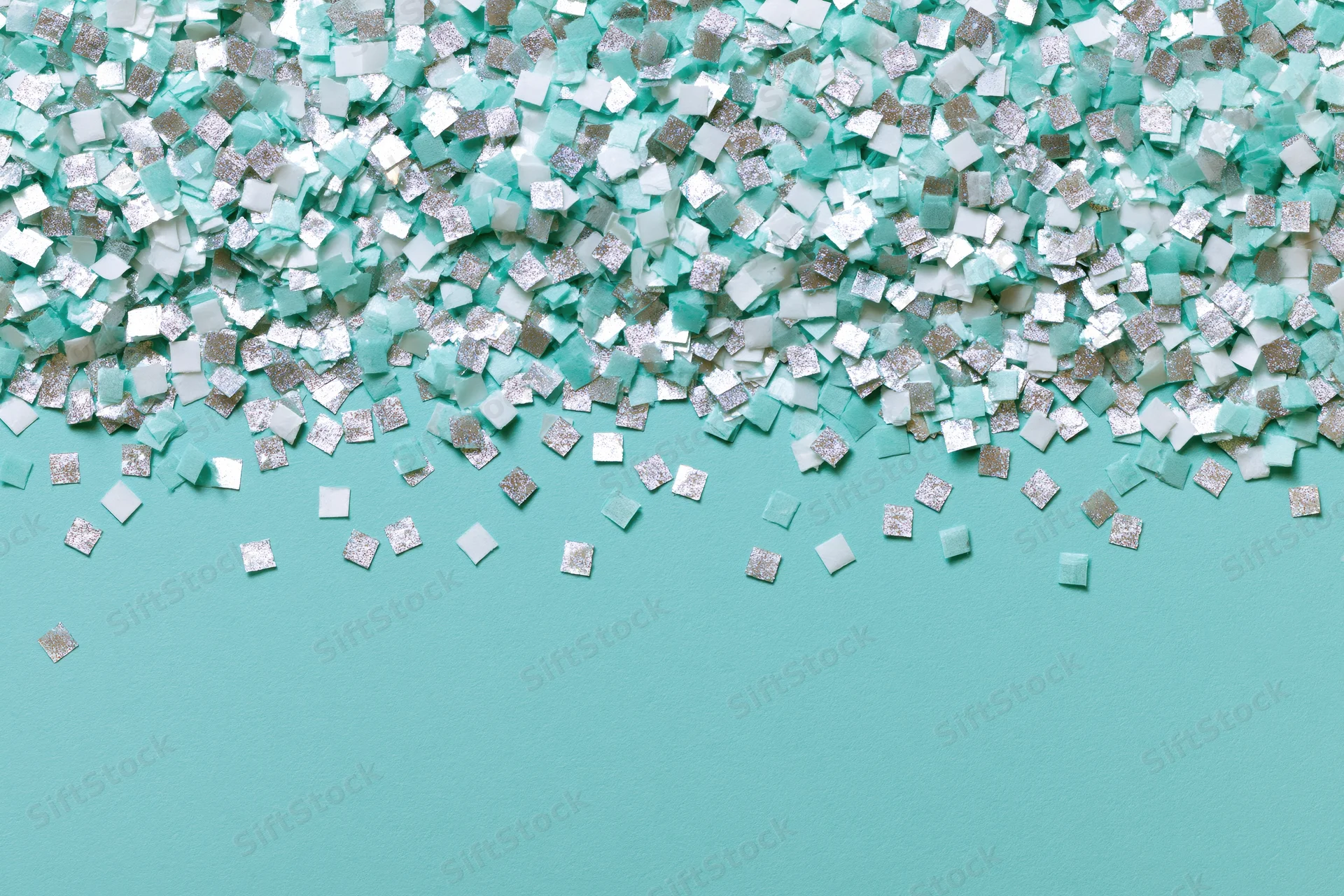 Square confetti pieces scattered densely at top and sparse at bottom on turquoise surface