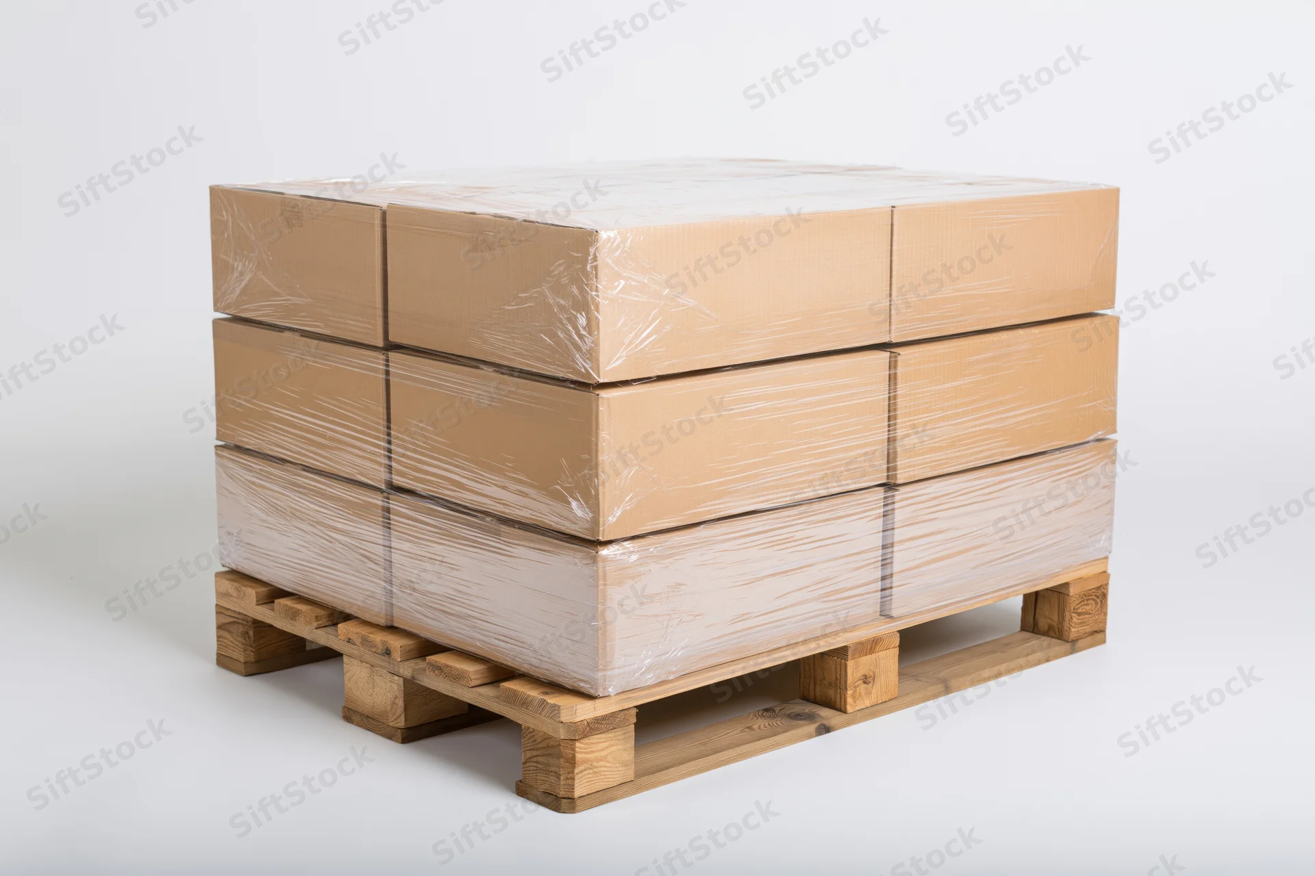 Stack of cardboard boxes wrapped in plastic on wooden pallet against white background