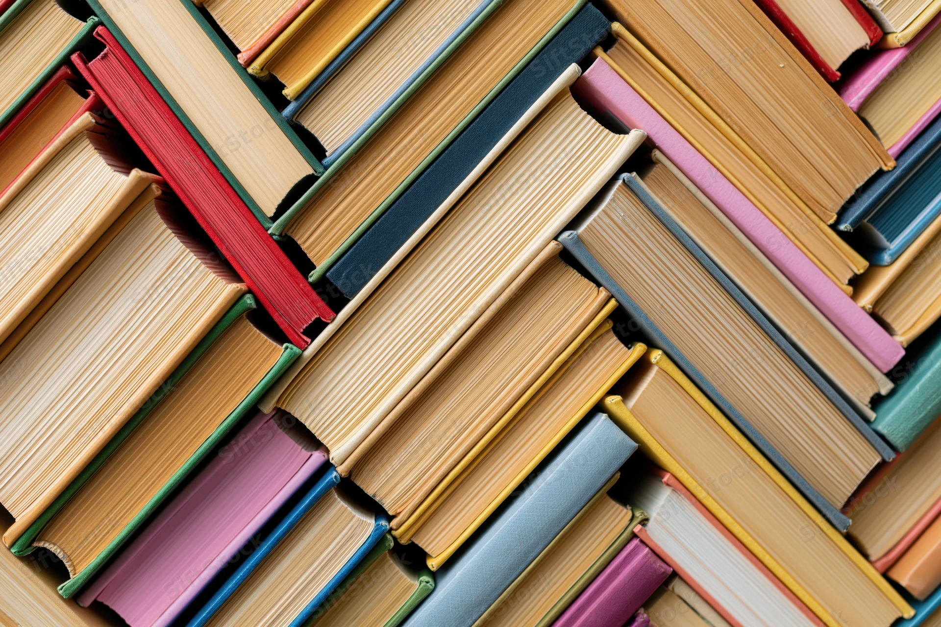 Stacks of hardcover books arranged in a herringbone diagonal pattern viewed from above