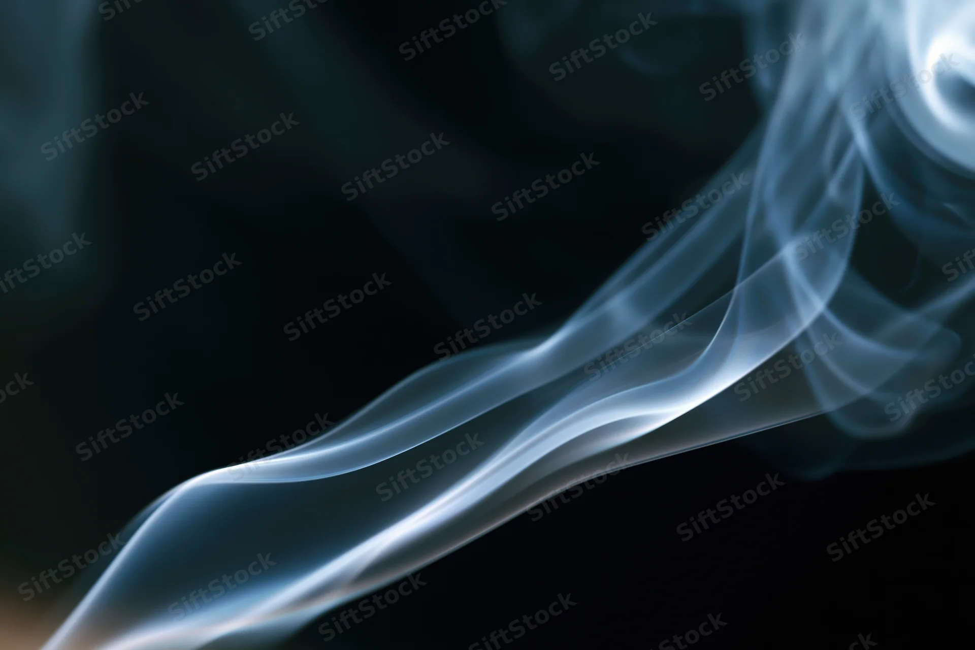 Thin wisp of white-grey smoke curling upward against dark background