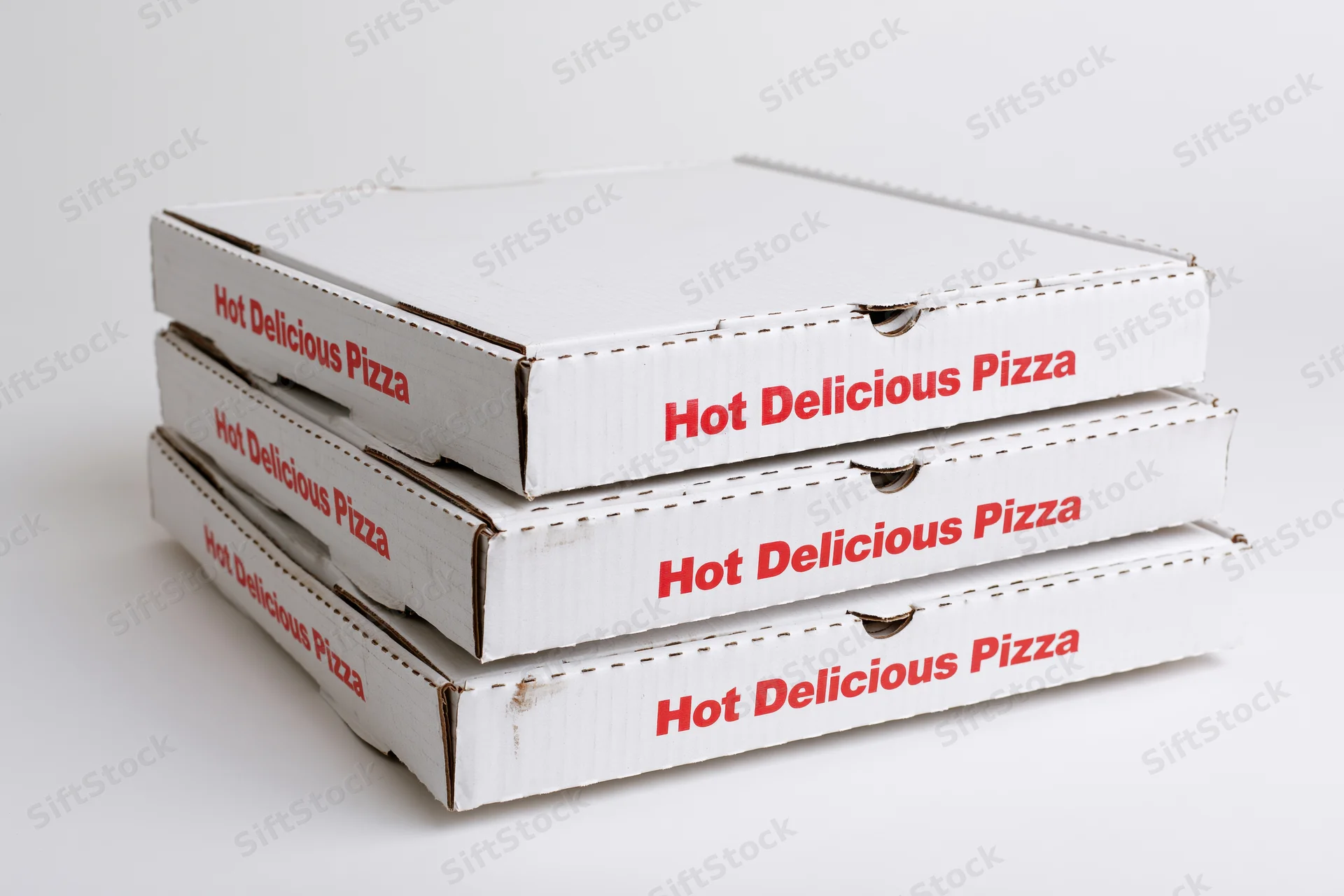 Three stacked white cardboard pizza delivery boxes with red text on a plain white surface