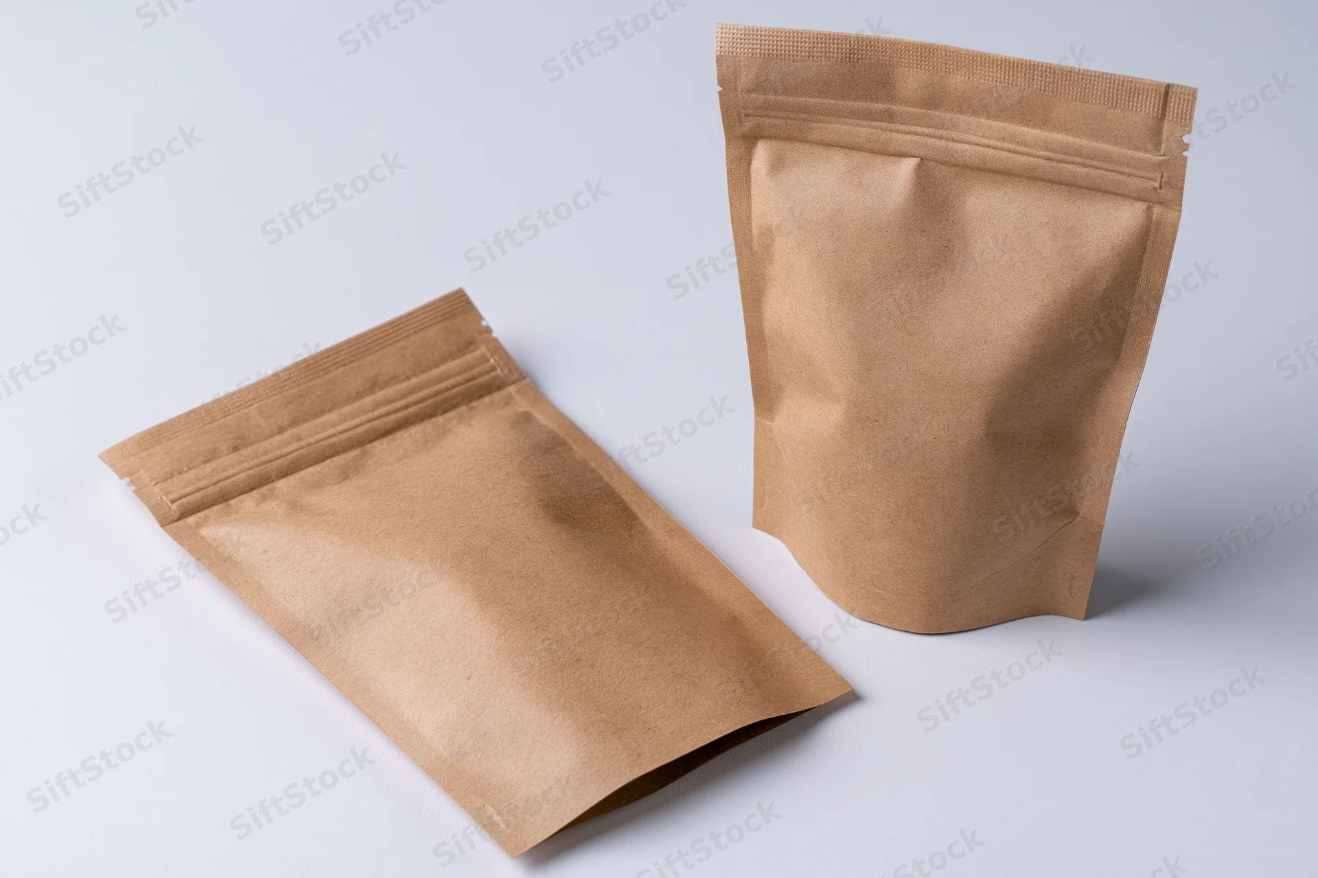 Two kraft paper resealable pouches arranged on a clean white surface