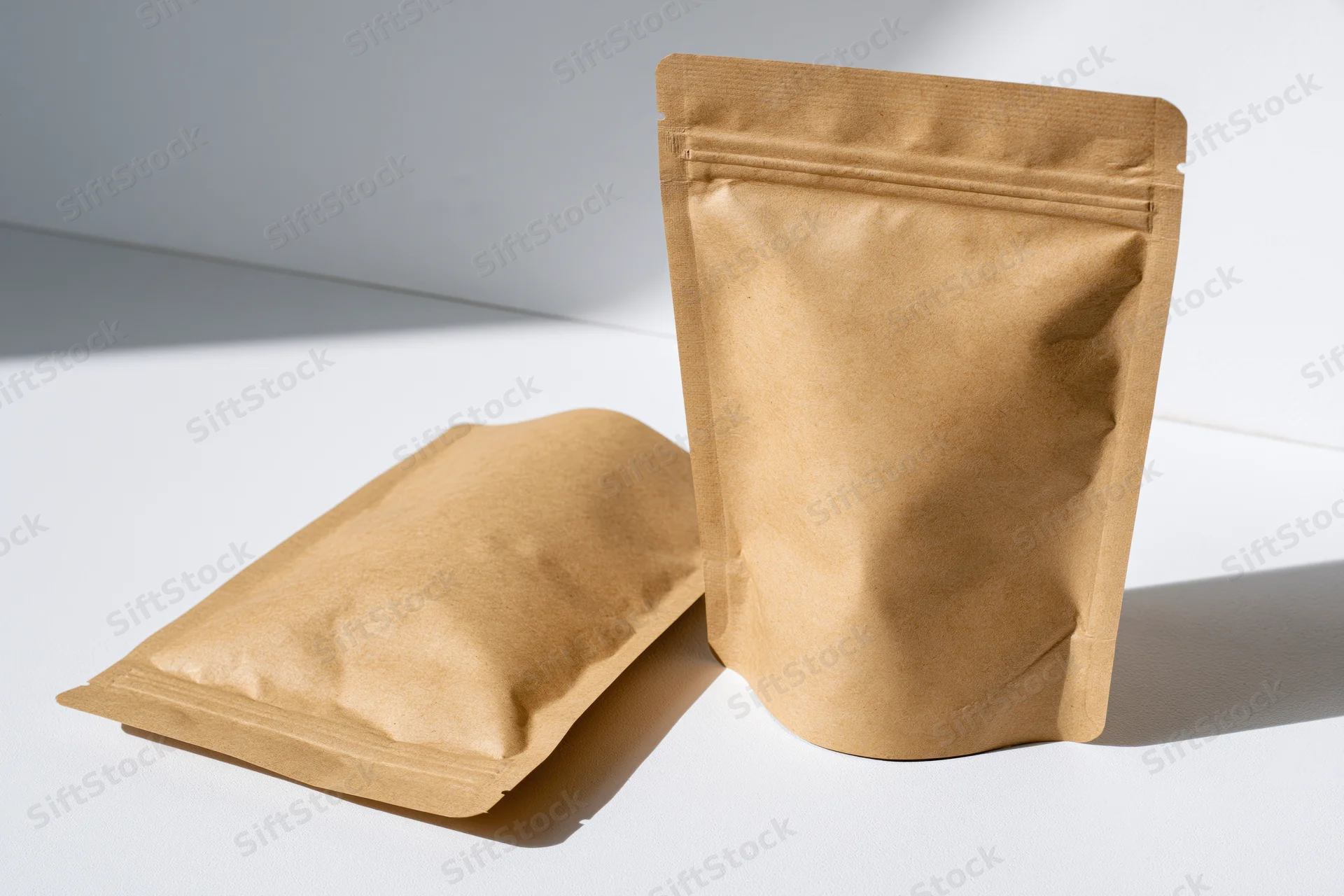 Two kraft paper resealable pouches arranged on a clean white surface
