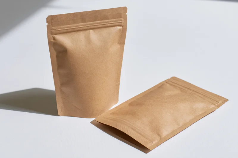 Two kraft paper resealable pouches arranged on a clean white surface