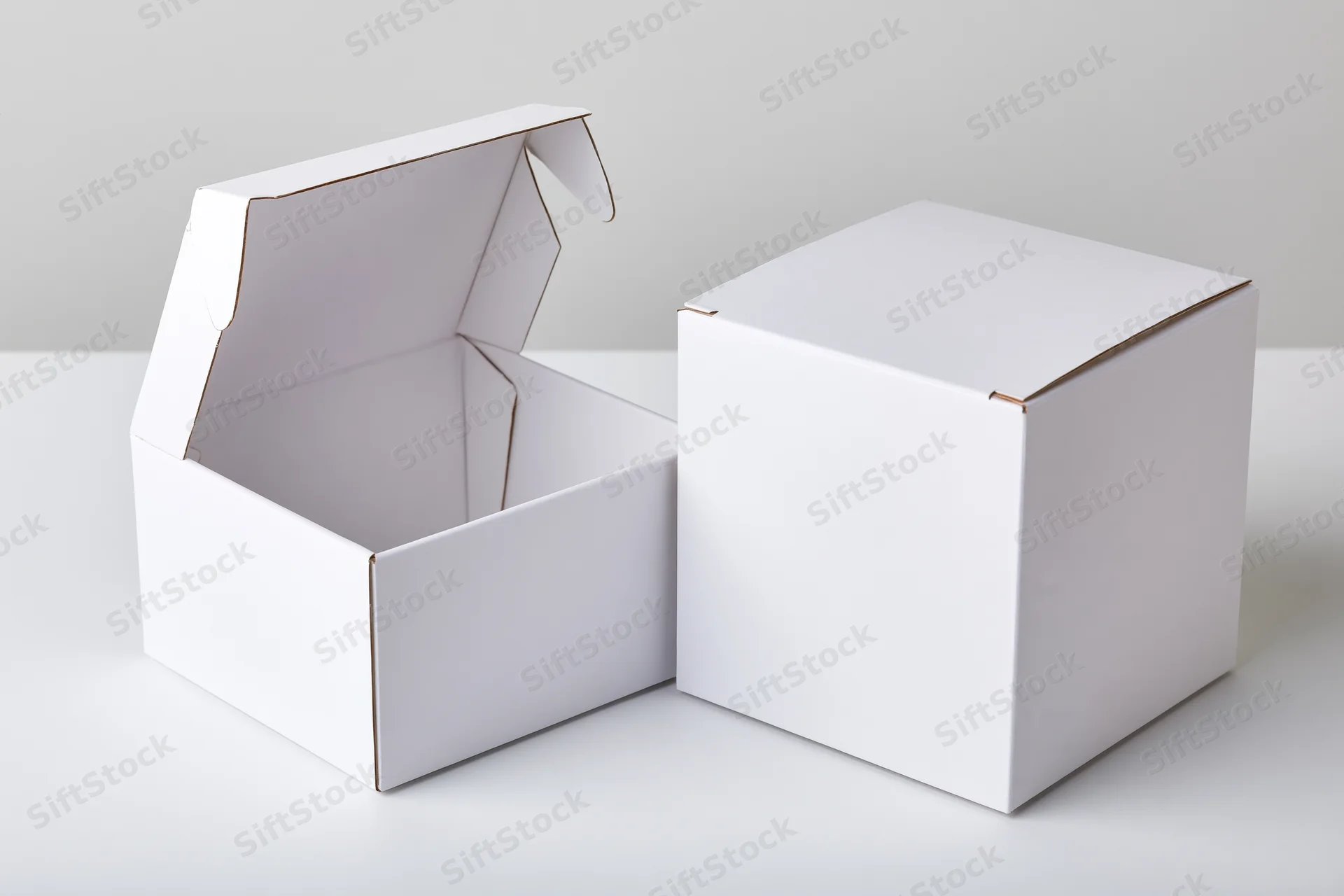 Two plain white cardboard flip-top boxes, one open and one closed, on a white surface
