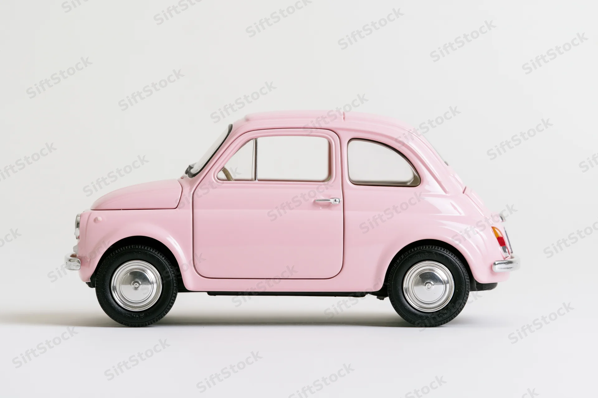 Pink vintage fiat 500 die-cast model car in side profile on white background