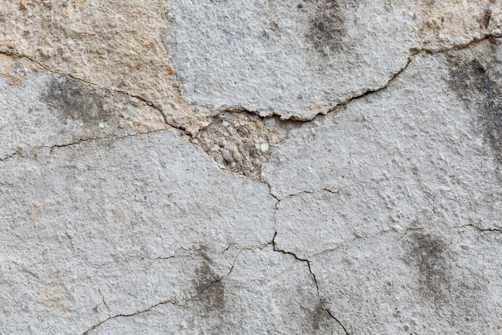 Cracked weathered concrete wall surface filling the frame