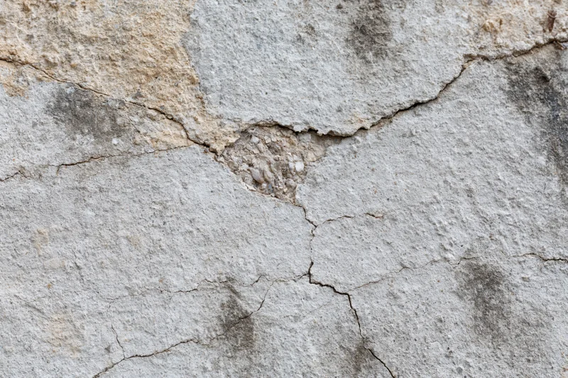 Cracked weathered concrete wall surface filling the frame
