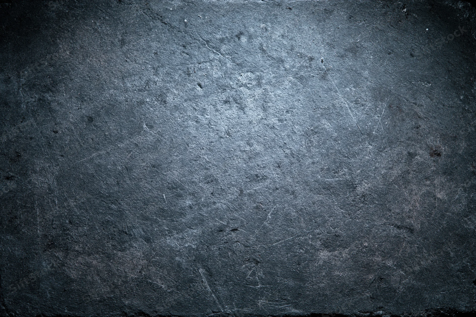 Weathered concrete wall surface filling the frame with dark vignette and visible cracks and scratches