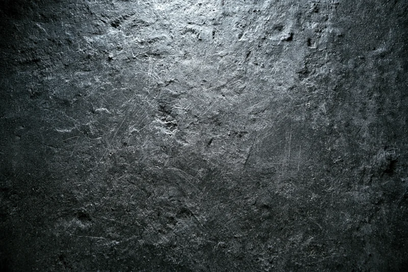 Weathered concrete wall surface filling the frame with rough texture and dark gray tones