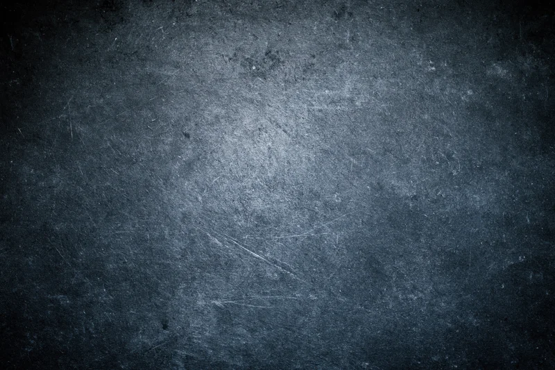 Weathered concrete wall surface filling the frame with visible scratches and dark gray tones