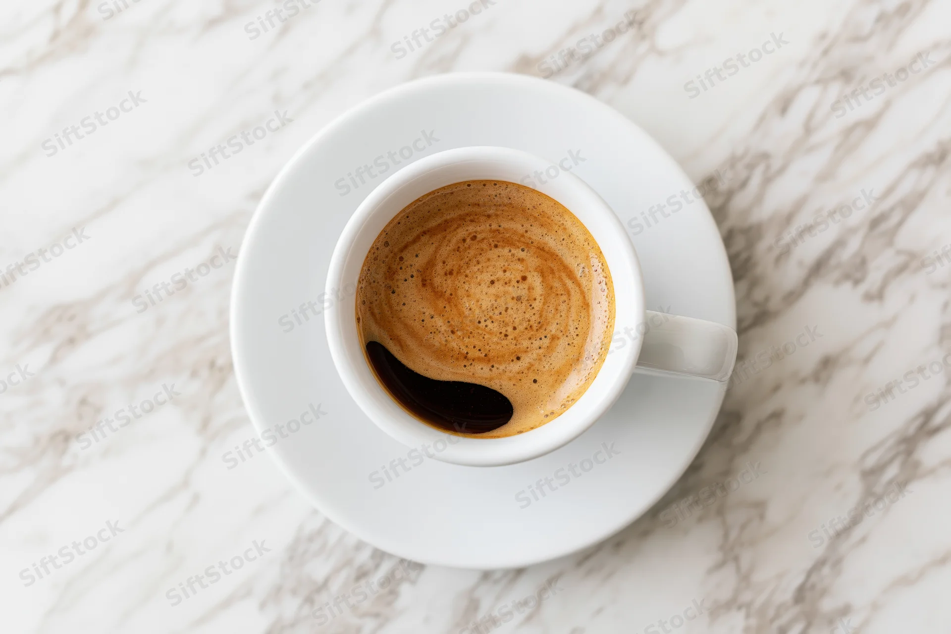 White ceramic espresso cup with crema and dark swirl on marble tabletop