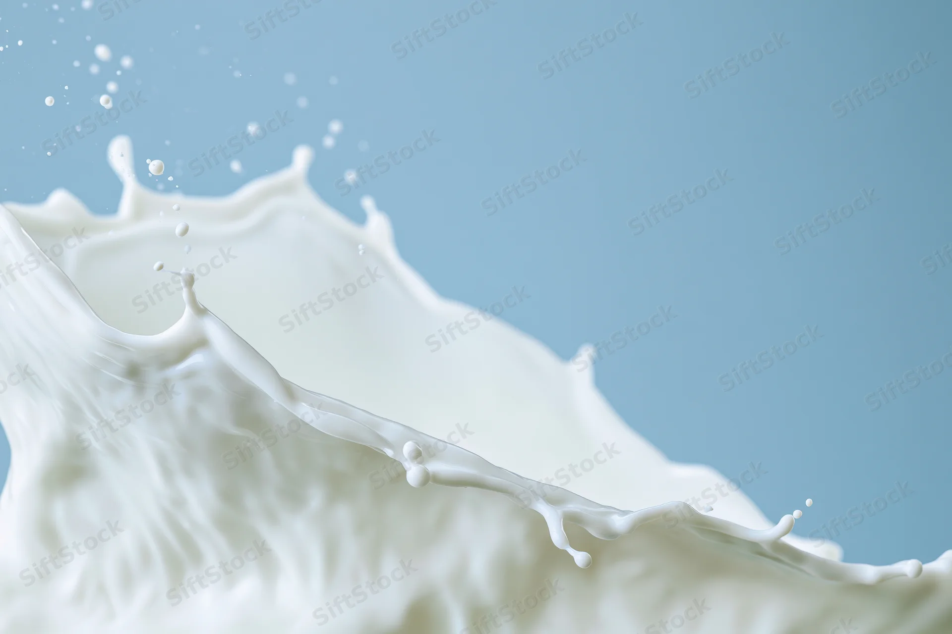 Milk splash forming a wave shape mid-motion against a light blue background