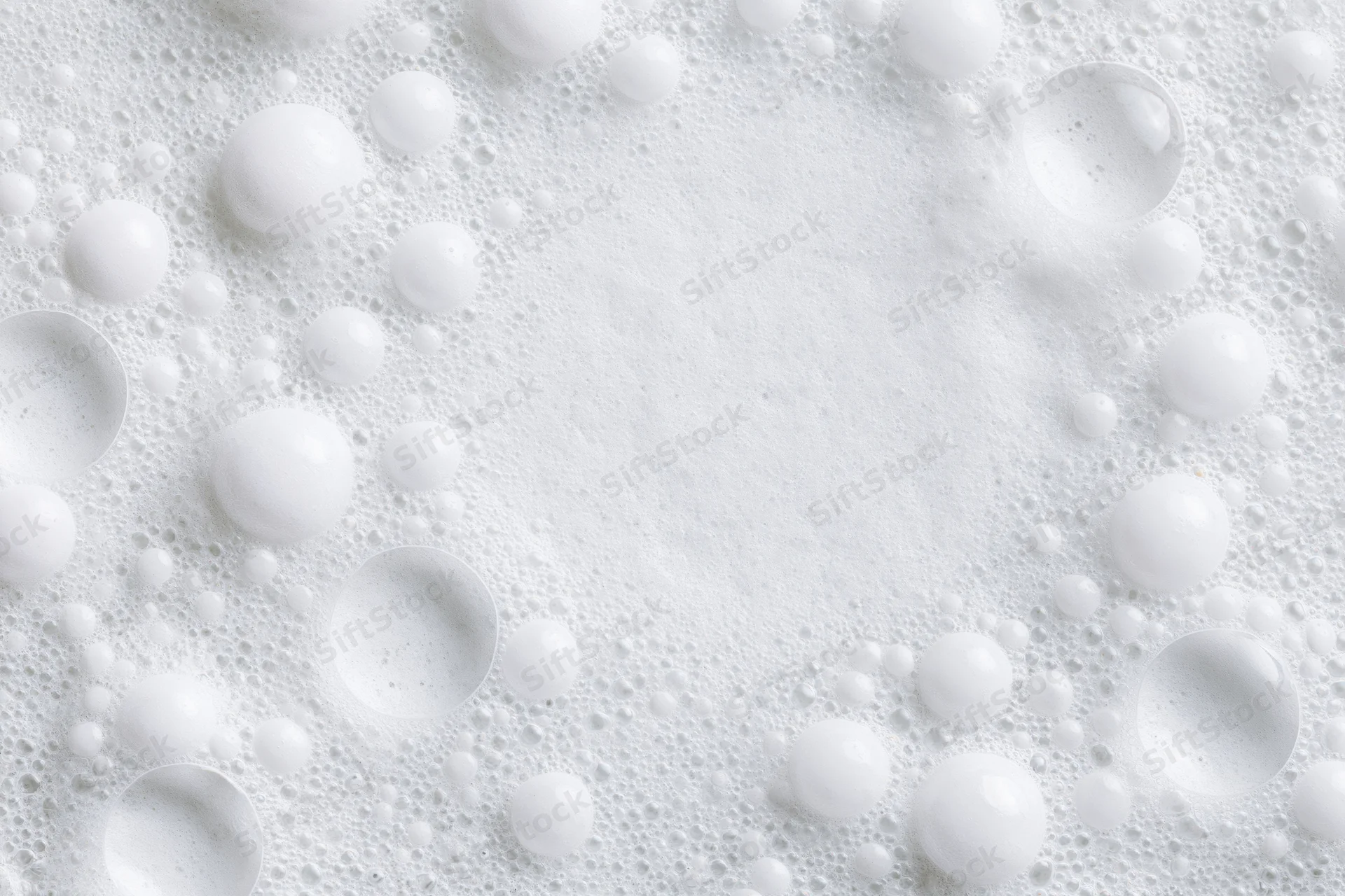 White soap foam with scattered bubbles forming a textured surface