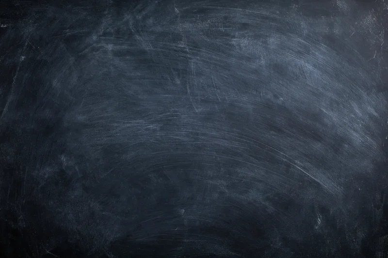 Worn chalkboard surface with smudged residue and scratches filling the frame