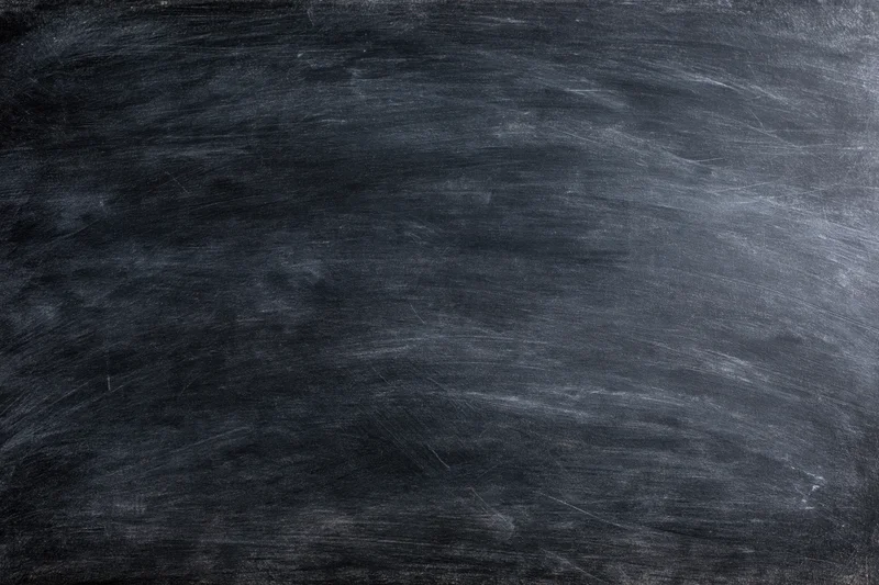 Worn chalkboard surface with smudged chalk residue filling the frame