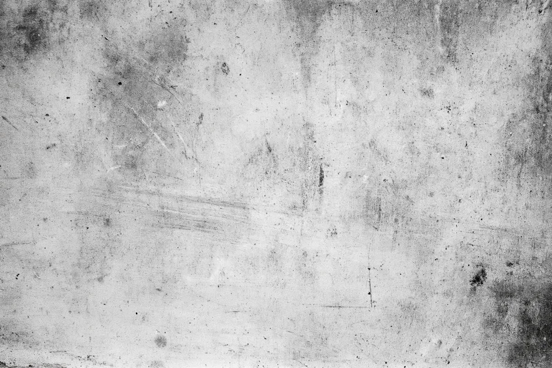 Worn concrete wall surface filling the frame with grunge texture and weathered marks