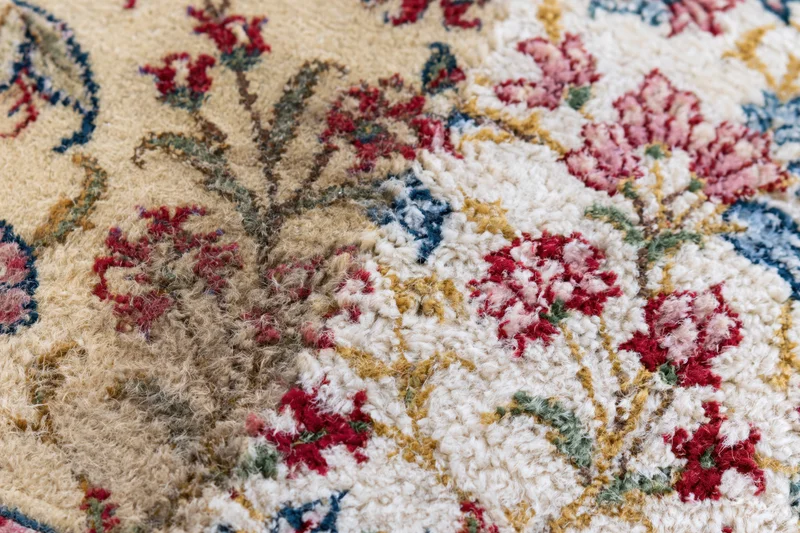Close-up of a Persian floral rug with intricate wool weave and vintage design